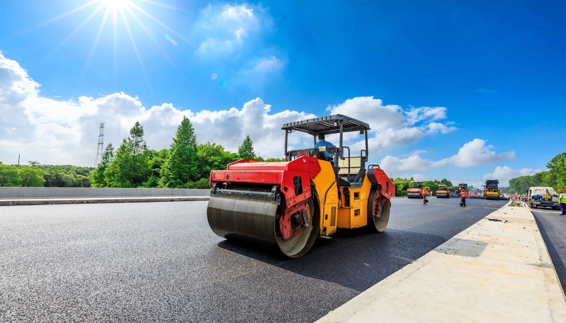 A team of construction workers operating heavy machinery, meticulously laying down fresh, smooth asphalt on a newly constructed road in Saint Petersburg, with steam rising from the hot surface.